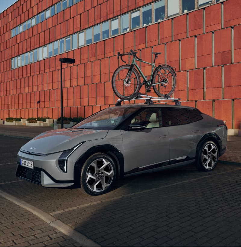 Kia EV4 ausgestattet mit dem Kia Dachträger und dem Kia Fahrradträger Plus.